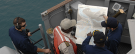 Photograph of sailors on deck  look for a route using a navigation map