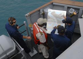 <p><strong>Fig. 8.2.</strong> US Navy officers navigate their warship into a foreign port with the aid of a local pilot and nautical chart.</p>

